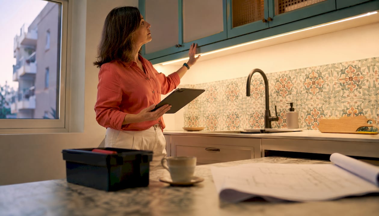 Woman inspecting renovated apartment kitchen