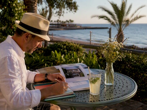 Hombre hojeando folletos de pisos en una terraza de Cambrils