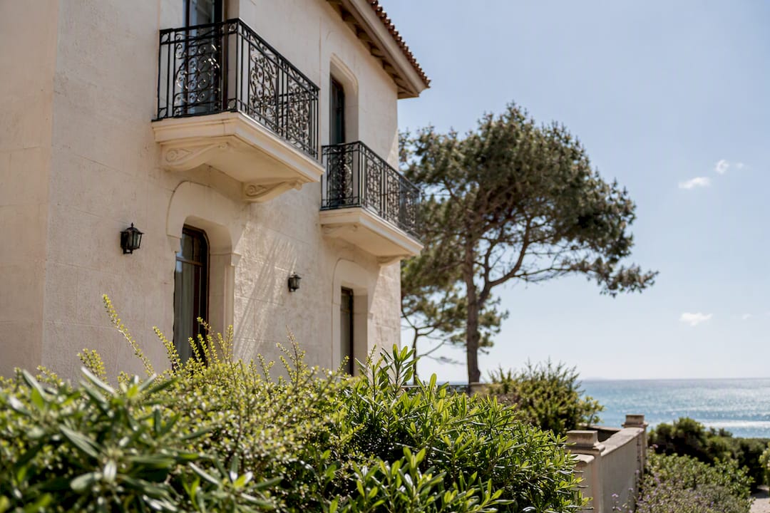 Manos podando arbustos en una casa costera del Mediterráneo