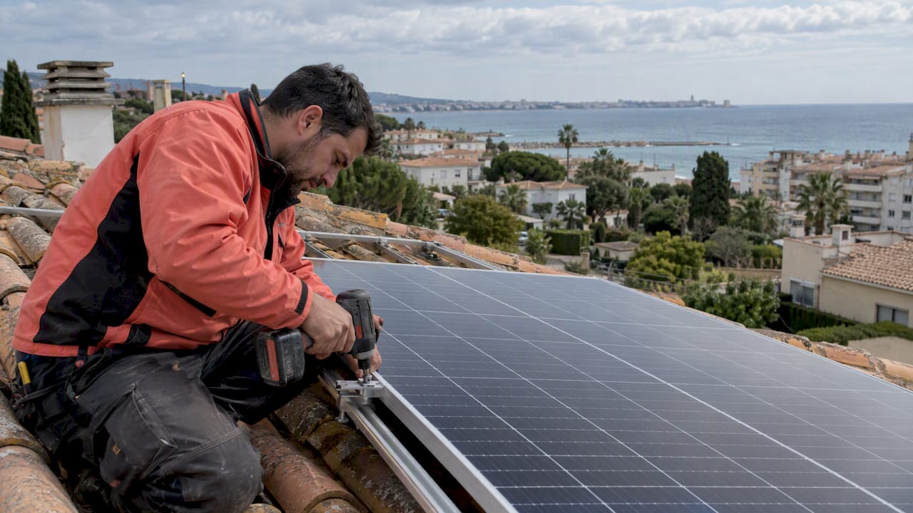 Instalador instala panel solar en casa junto al mar